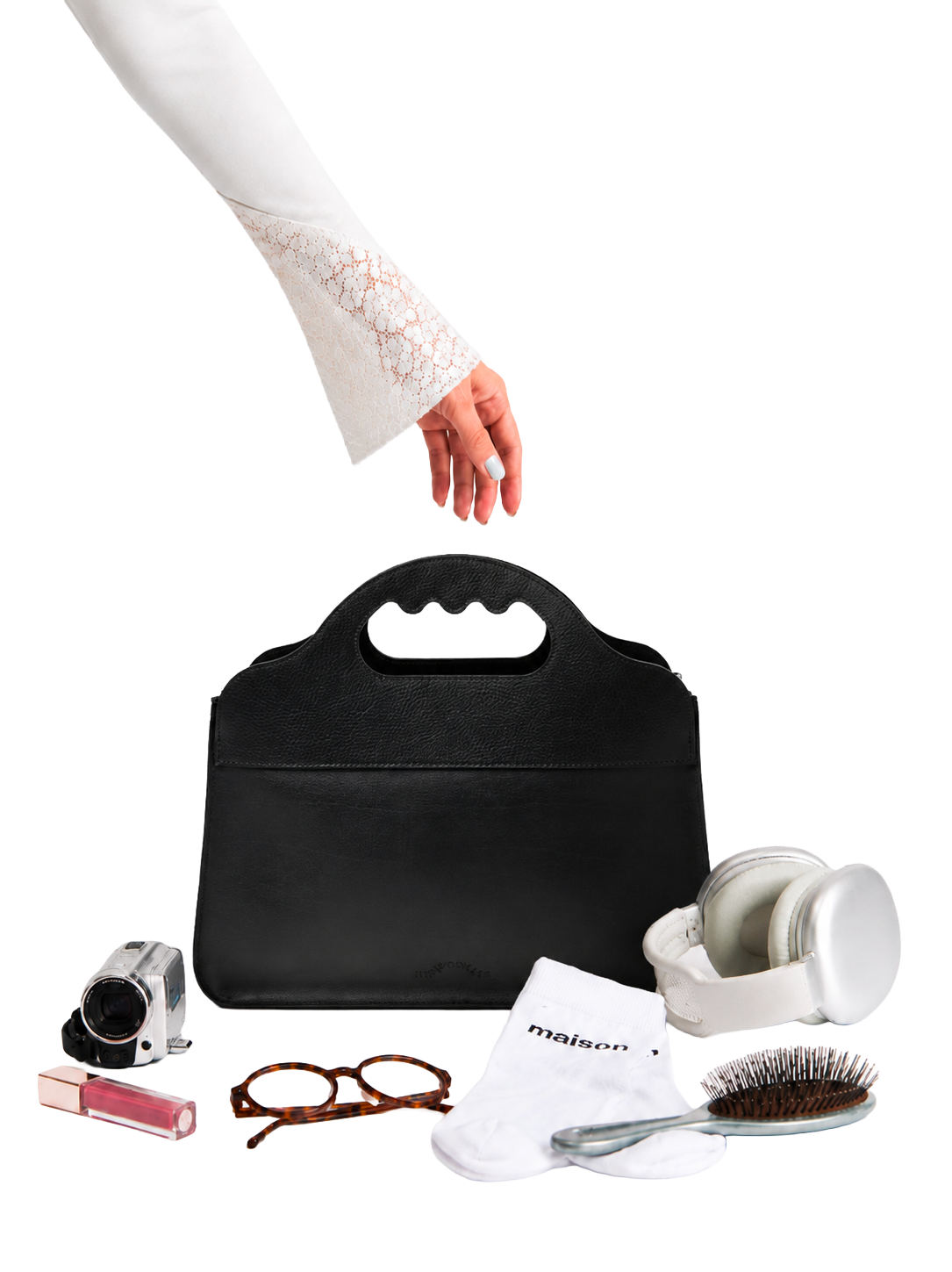 Le sac Lua entouré d'objets du quotidien, une main descend vers lui