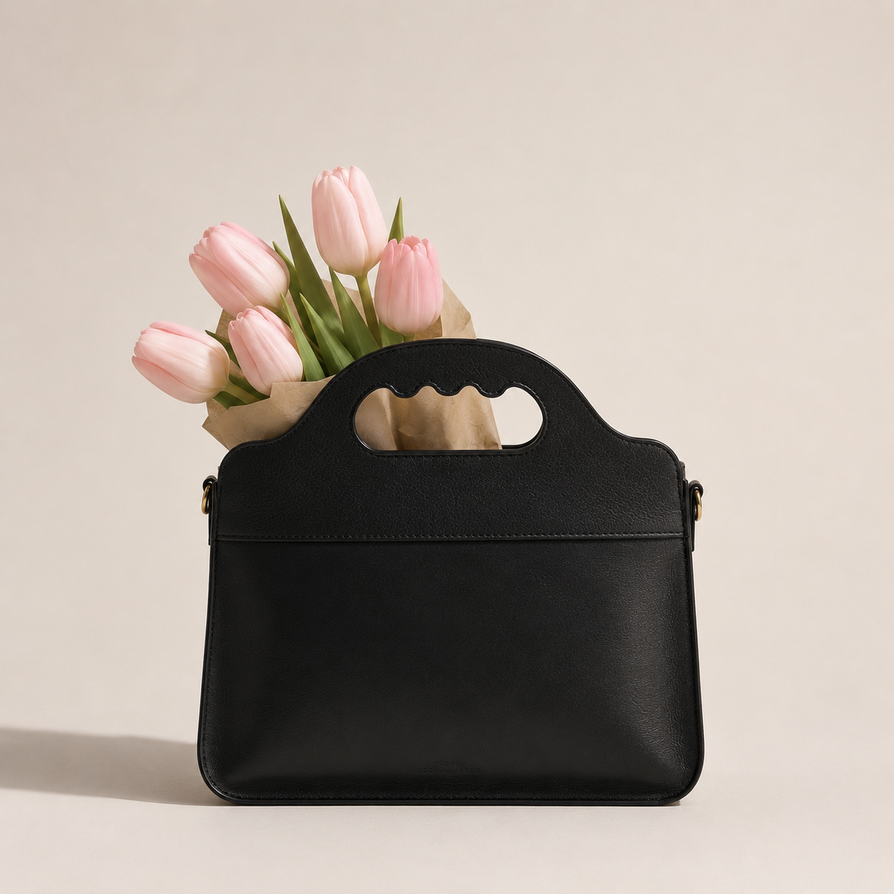Le sac Lua noir garni d'un bouquet de tulipes roses